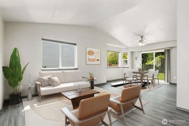 living area featuring vaulted ceiling, baseboards, a ceiling fan, and wood finished floors