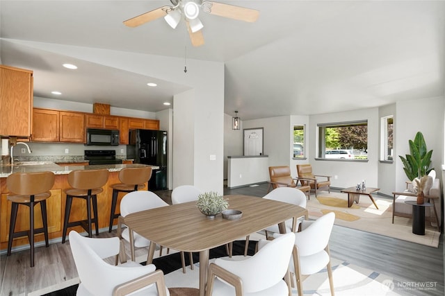 dining area featuring light wood-style floors, vaulted ceiling, ceiling fan, and recessed lighting