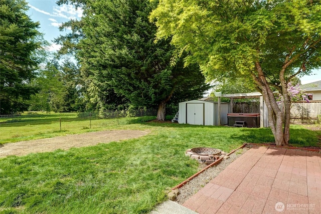 view of yard featuring an outbuilding, a hot tub, a patio, a fenced backyard, and a storage unit