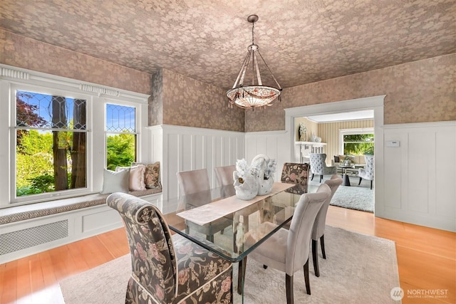 2234 Main St, Ferndale, WA 98248 - dining space featuring plenty of natural light, wainscoting, a chandelier, wallpapered walls, and wood finished floors