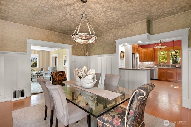 2234 Main St, Ferndale, WA 98248 - dining space featuring plenty of natural light, a wainscoted wall, light wood finished floors, a decorative wall, and wallpapered walls
