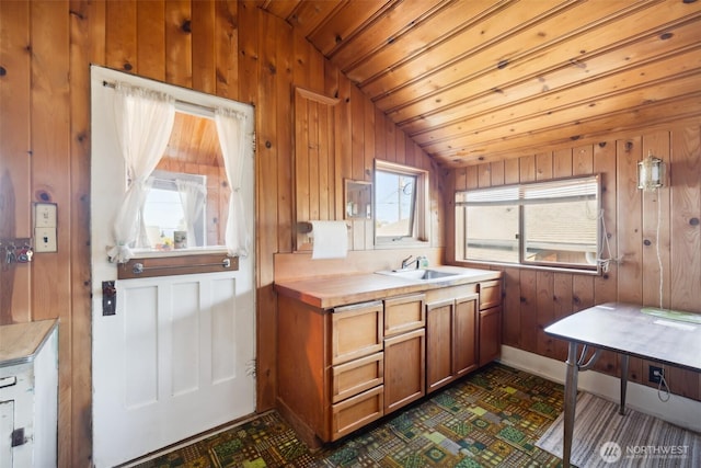 219 W 15th St, Port Angeles, WA 98362 - kitchen with light countertops, wood walls, brown cabinetry, and a sink