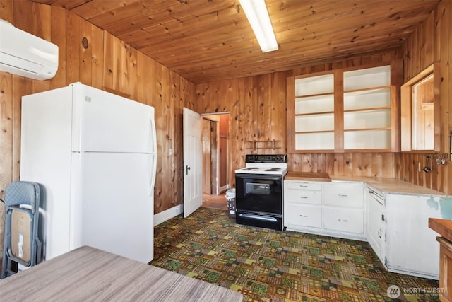 219 W 15th St, Port Angeles, WA 98362 - kitchen featuring wood walls, a wall mounted air conditioner, freestanding refrigerator, light countertops, and range with electric cooktop