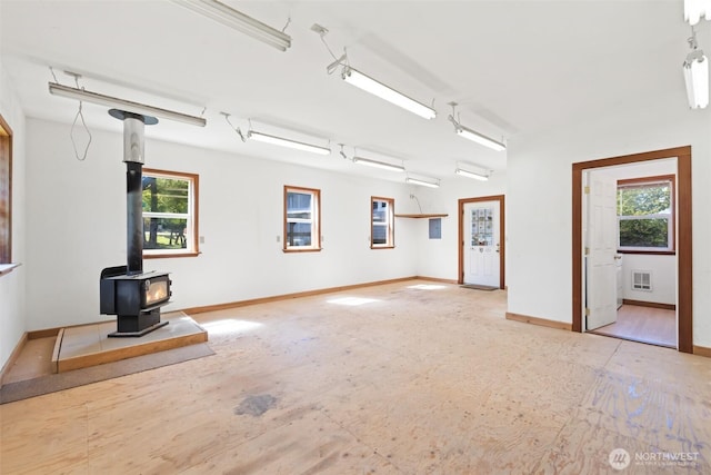 219 W 15th St, Port Angeles, WA 98362 - unfurnished living room featuring a wood stove, baseboards, and visible vents