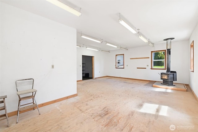 219 W 15th St, Port Angeles, WA 98362 - spare room featuring a wood stove, baseboards, and wood finished floors