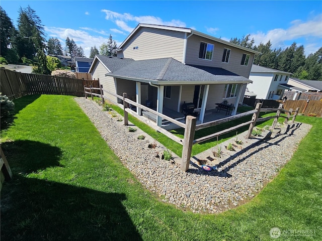 back of house with a shingled roof, a yard, a patio area, and a fenced backyard