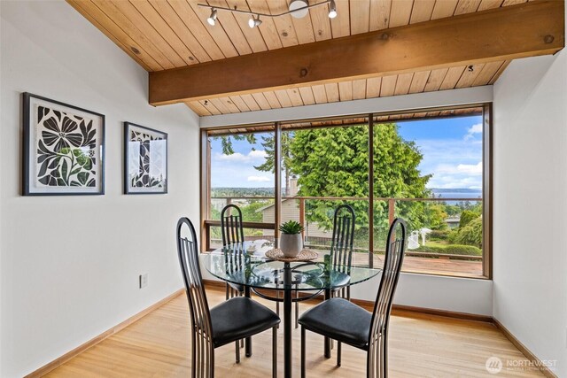 517 S 212th St, Des Moines, WA 98198 - dining area with beam ceiling, light wood-type flooring, wood ceiling, baseboards, and a water view