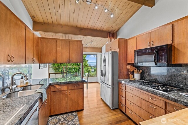517 S 212th St, Des Moines, WA 98198 - kitchen featuring stainless steel appliances, a sink, tasteful backsplash, light wood finished floors, and brown cabinetry