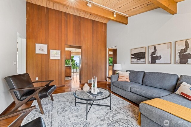 517 S 212th St, Des Moines, WA 98198 - living room featuring rail lighting, wood ceiling, wood finished floors, a high ceiling, and wood walls
