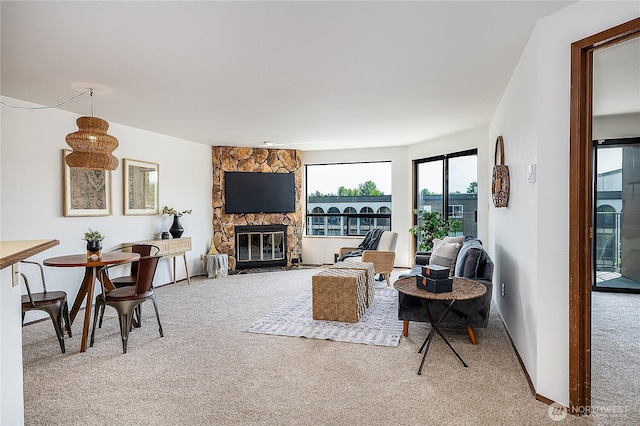 10601 Bagley Ave N Unit 204, Seattle, WA 98133 - carpeted living area featuring a stone fireplace and baseboards