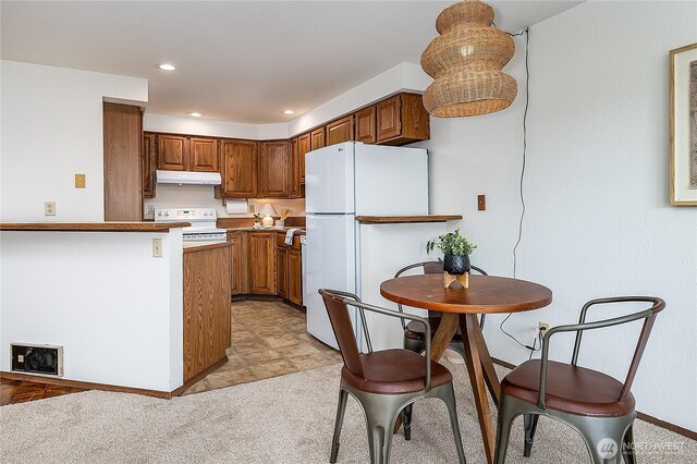 10601 Bagley Ave N Unit 204, Seattle, WA 98133 - kitchen featuring under cabinet range hood, white appliances, brown cabinets, baseboards, and recessed lighting