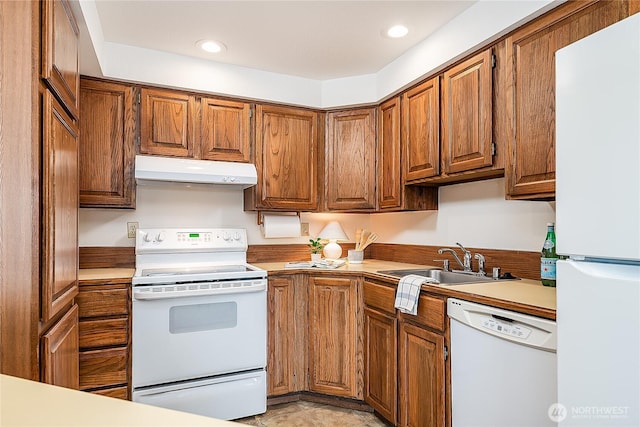 10601 Bagley Ave N Unit 204, Seattle, WA 98133 - kitchen with white appliances, under cabinet range hood, a sink, brown cabinets, and recessed lighting