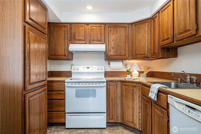 10601 Bagley Ave N Unit 204, Seattle, WA 98133 - kitchen with white appliances, under cabinet range hood, a sink, brown cabinetry, and recessed lighting