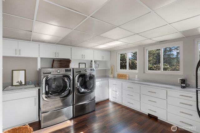 clothes washing area featuring a sink, dark wood finished floors, and washer and dryer