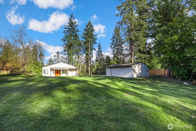 view of yard with an outdoor structure and fence