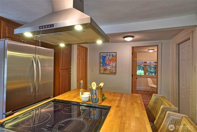10733 14th Ave NE, Seattle, WA 98125 - kitchen featuring butcher block countertops, range hood, freestanding refrigerator, baseboards, and stove