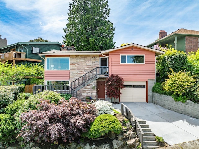 2537 Montavista Pl W, Seattle, WA 98199 - view of front of property featuring stairs, an attached garage, concrete driveway, and stone siding