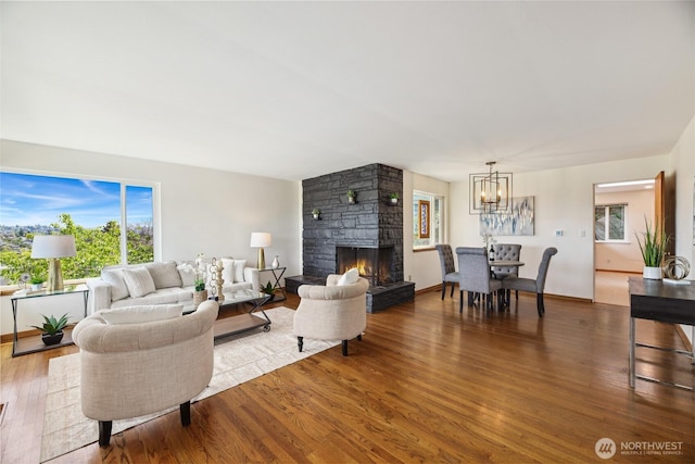 2537 Montavista Pl W, Seattle, WA 98199 - living room with a chandelier, healthy amount of natural light, wood finished floors, and a stone fireplace