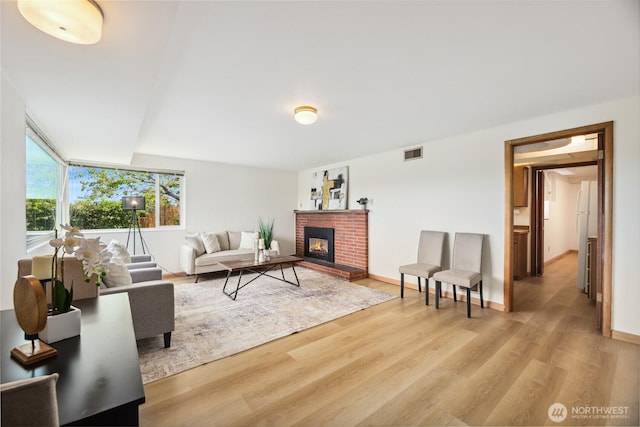 2537 Montavista Pl W, Seattle, WA 98199 - living area with wood finished floors, a brick fireplace, and baseboards