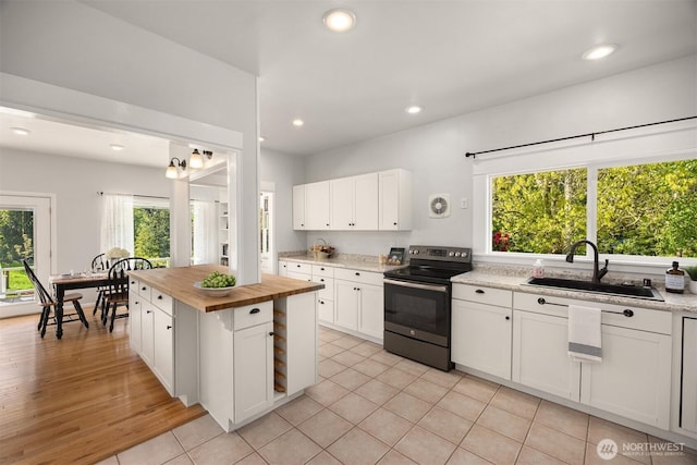 kitchen featuring a sink, white cabinetry, electric stove, butcher block counters, and recessed lighting