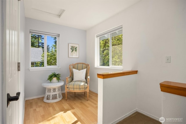 sitting room featuring baseboards, attic access, plenty of natural light, and wood finished floors