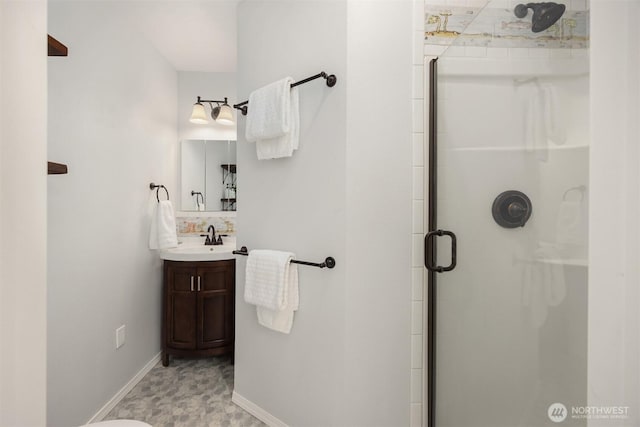 bathroom featuring a stall shower, backsplash, baseboards, and vanity