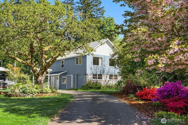 view of front facade featuring a front yard and aphalt driveway