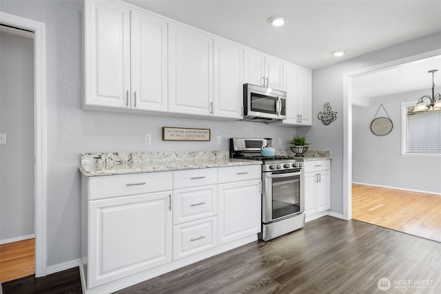 kitchen with appliances with stainless steel finishes, dark wood-style flooring, white cabinets, baseboards, and recessed lighting