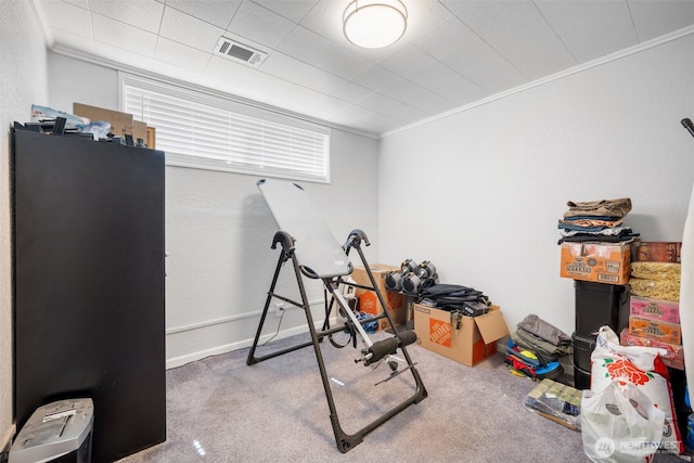 exercise area featuring carpet flooring, ornamental molding, and baseboards