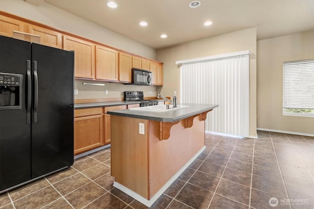 5305 Military Rd E Unit D, Tacoma, WA 98446 - kitchen featuring black fridge, gas stove, light brown cabinets, recessed lighting, and an island with sink