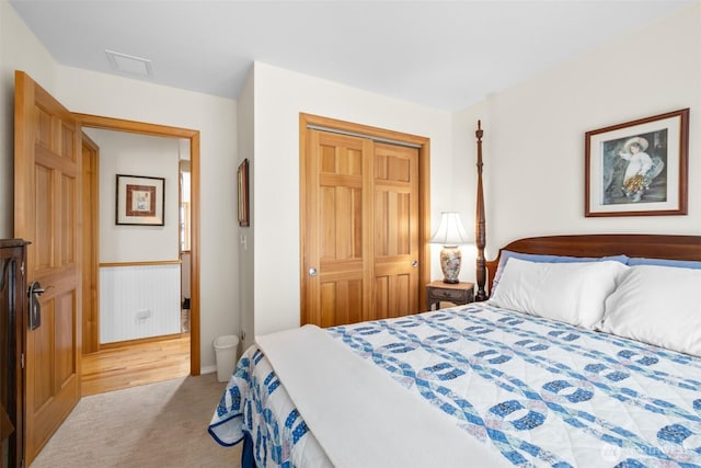 carpeted bedroom with a closet and baseboards