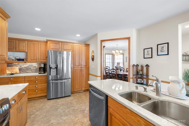 kitchen featuring appliances with stainless steel finishes, a sink, a chandelier, recessed lighting, and backsplash
