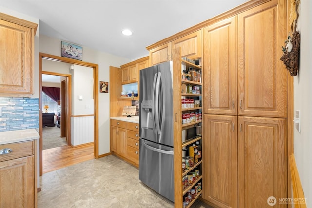 kitchen with stainless steel fridge with ice dispenser, light countertops, and recessed lighting