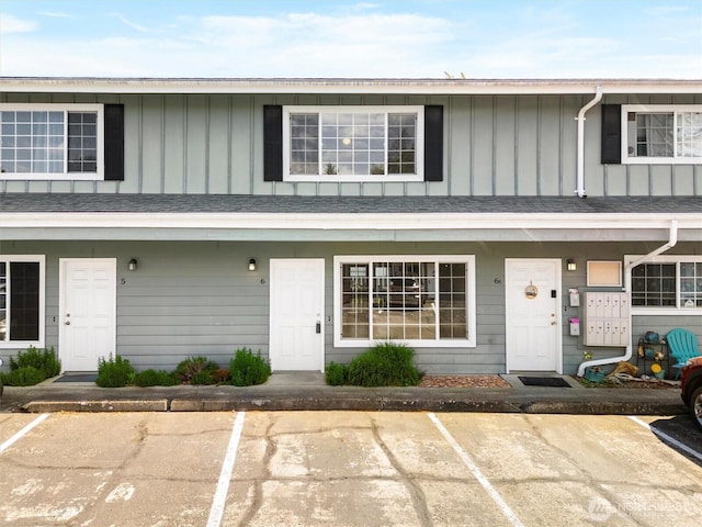 townhome / multi-family property with board and batten siding and uncovered parking