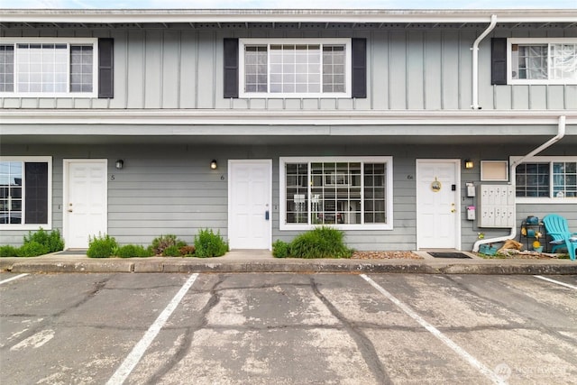 view of front facade with board and batten siding and uncovered parking