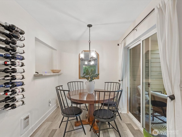 455 Newport Way NW Unit 302, Issaquah, WA 98027 - dining room with light wood-type flooring, baseboards, and a chandelier