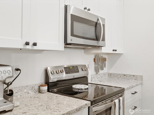 455 Newport Way NW Unit 302, Issaquah, WA 98027 - kitchen featuring stainless steel appliances, white cabinets, and light stone counters