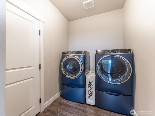 laundry room with washer and dryer, dark wood finished floors, and baseboards