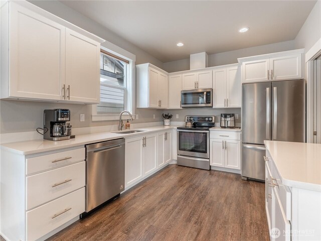 kitchen with appliances with stainless steel finishes, a sink, white cabinetry, and recessed lighting
