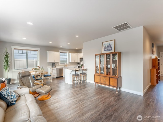 living area with dark wood-style floors, baseboards, and recessed lighting
