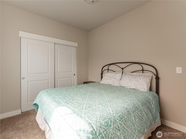bedroom featuring carpet flooring, baseboards, and a closet