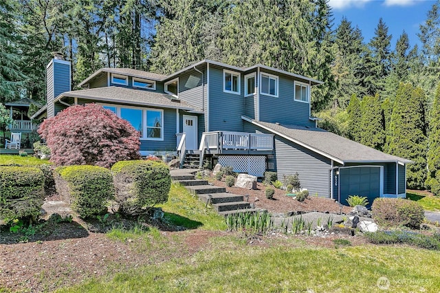 tri-level home with a chimney, a garage, a shingled roof, stairway, and a wooden deck