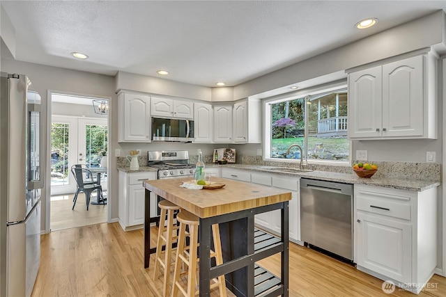 kitchen with light wood finished floors, stainless steel appliances, and a sink