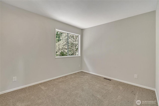 unfurnished room with visible vents, baseboards, and carpet floors