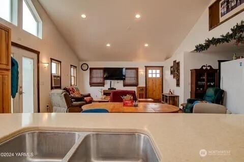 kitchen with recessed lighting, light countertops, open floor plan, and high vaulted ceiling