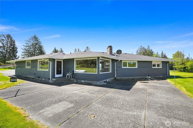 206 Kelly Rd, Bellingham, WA 98226 - view of front facade featuring roof with shingles, a patio area, and a chimney