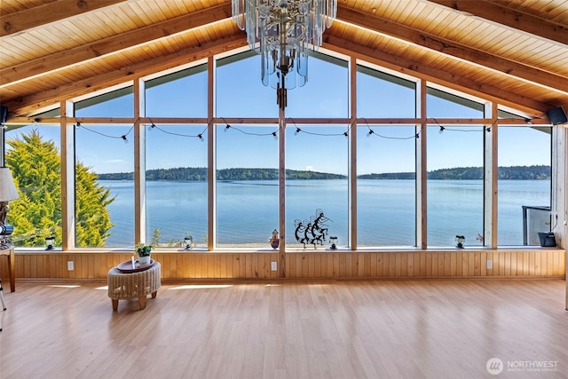 unfurnished sunroom with a chandelier and a water view