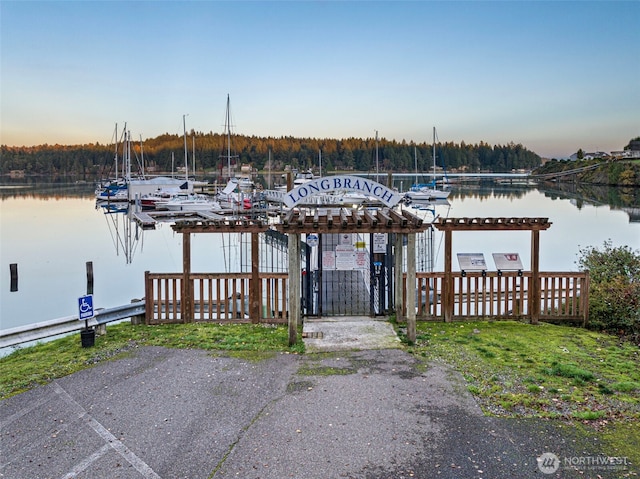 dock with a water view, a gate, and fence