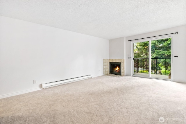 unfurnished living room featuring a textured ceiling, a tiled fireplace, baseboard heating, and carpet floors