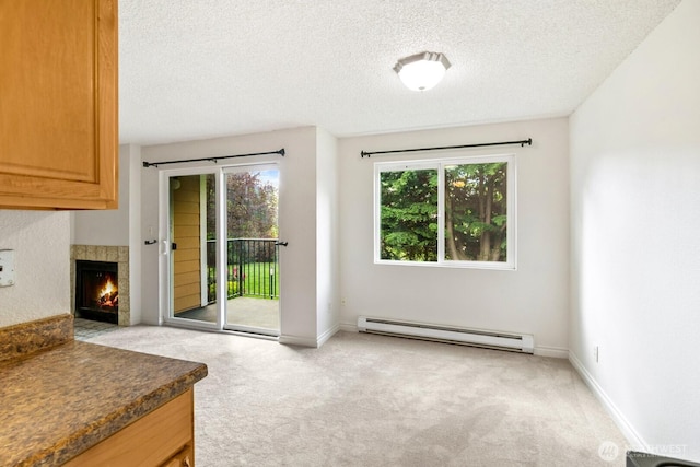 doorway to outside featuring a textured ceiling, baseboard heating, and light colored carpet